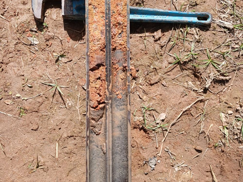 Amostrador SPT com amostra de solo residual vermelho